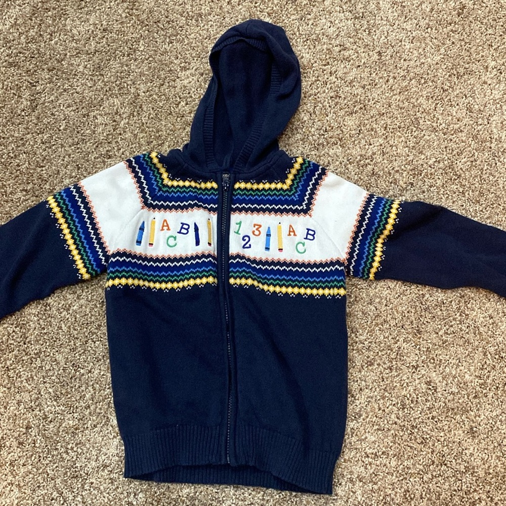 Gymboree size 7 zip up sweater. New without tags. Base color is navy blue.